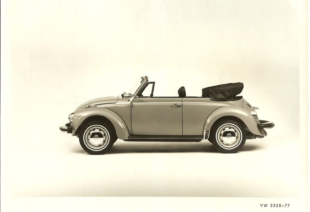 Volkswagen promo picture of a 1977 VW Super Beetle 1303 Cabriolet, produced by Karmann for Volkswagen. It is a significant automotive icon known for its unique silhouette and rear-engine design.
