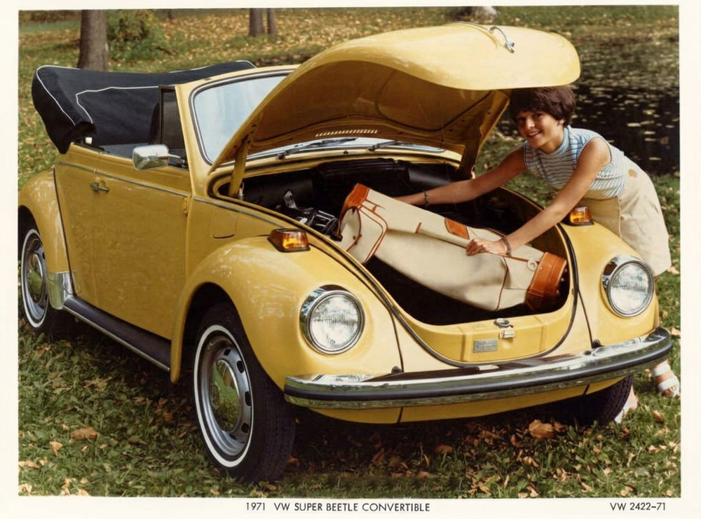 Yellow 1971 Super Beetle Convertible with front trunk open as luggage is loaded.
