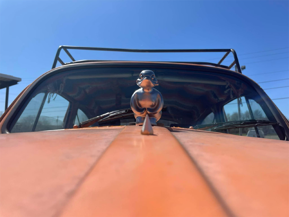 Orange VW Bug with a duck on the hood