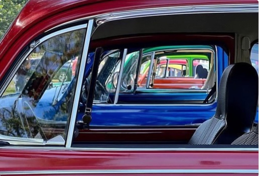 1302 Super Beetles lined up in a row at a VW Show