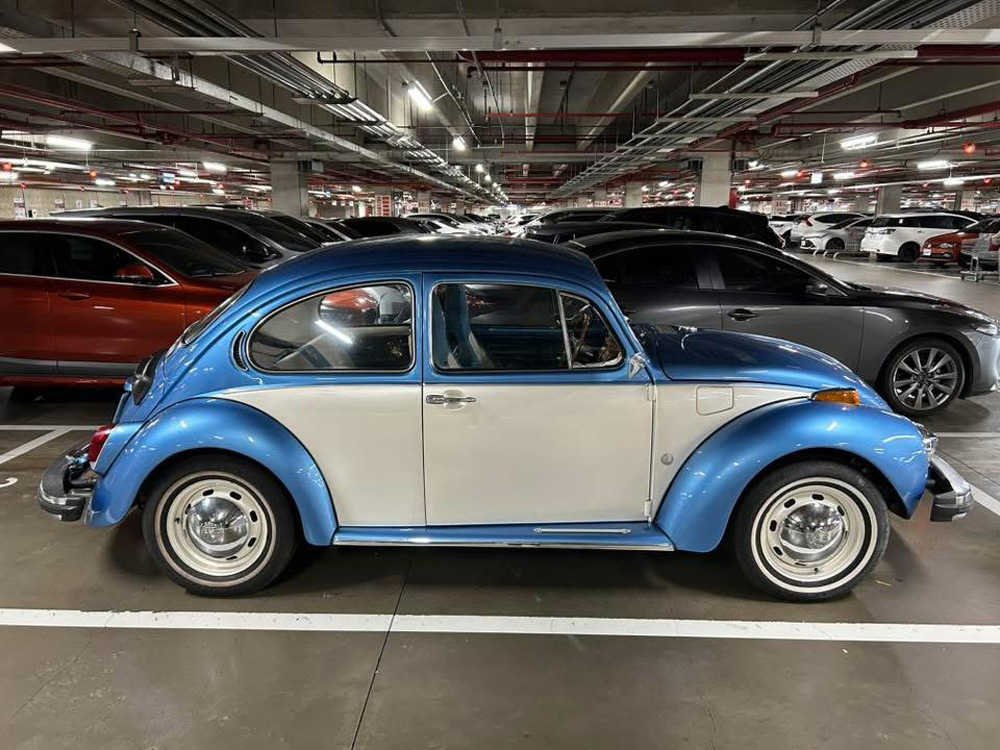Two Tone super Beetle in a parking lot