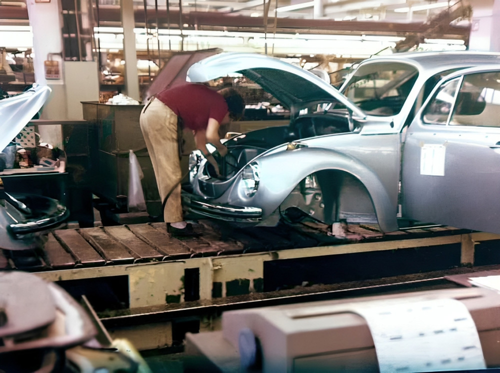 Worker assembling a blue Volkswagen Weltmeister Beetle on the production line during the 1972 Marathon era
