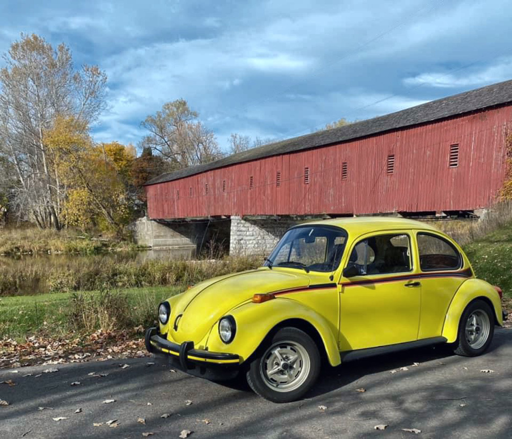 Volkswagen Sports Bug by a covered bridge