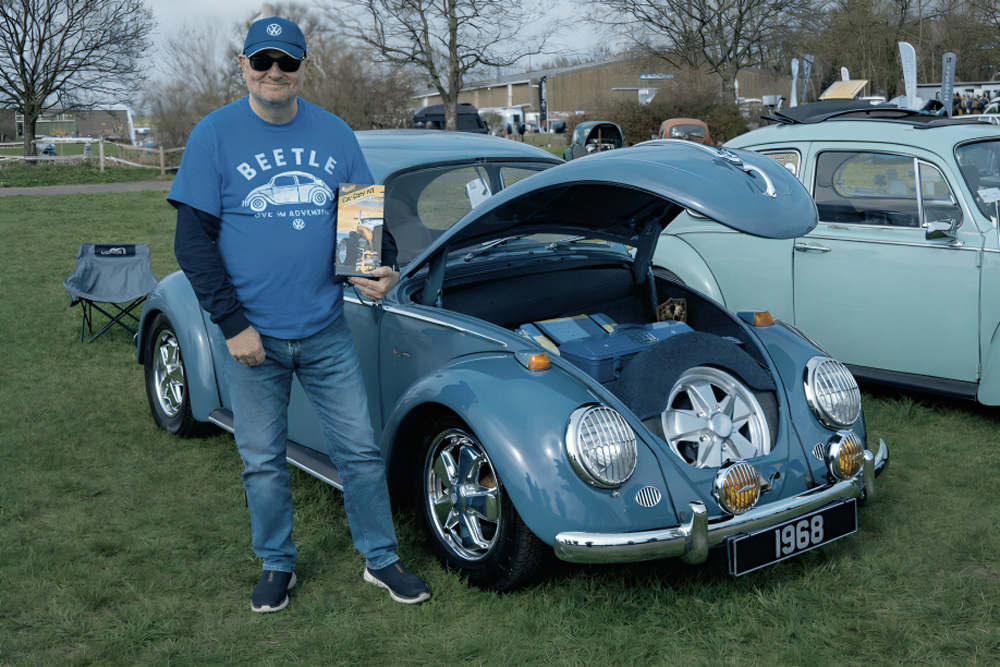 Modified VW Beetles on red carpet display inside the Volksworld Show hall.