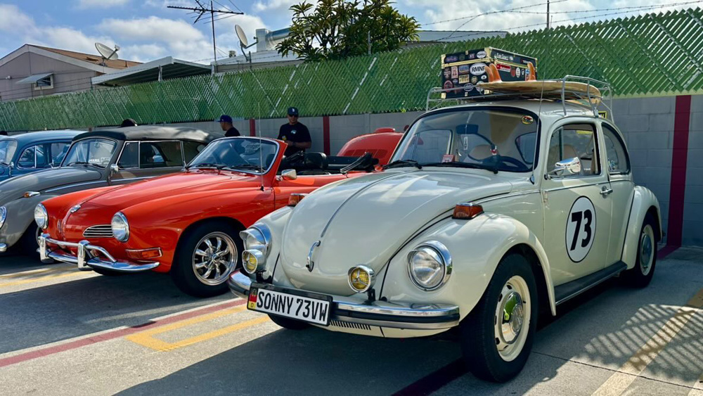 White Volkswagen Beetle with number 73 and a Karmann Ghia beside it at the EMPI 70th Anniversary Open House