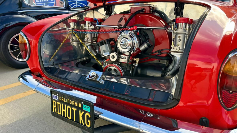 Rear view of a red Karmann Ghia with a detailed chrome engine at the EMPI 70th Anniversary Open House