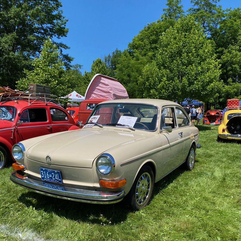 Beige vintage Volkswagen Type 3 parked on grass at Germanaire with other show cars behind it