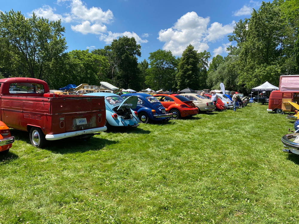 Classic Volkswagens lined up on the Germanaire show field with tents and spectators nearby