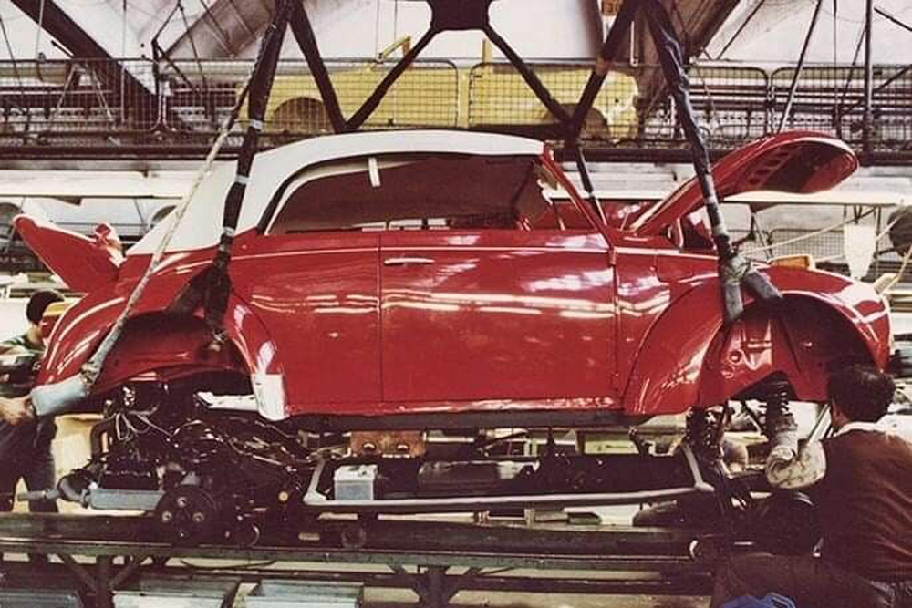 Red Super Beetle lowered onto chassis