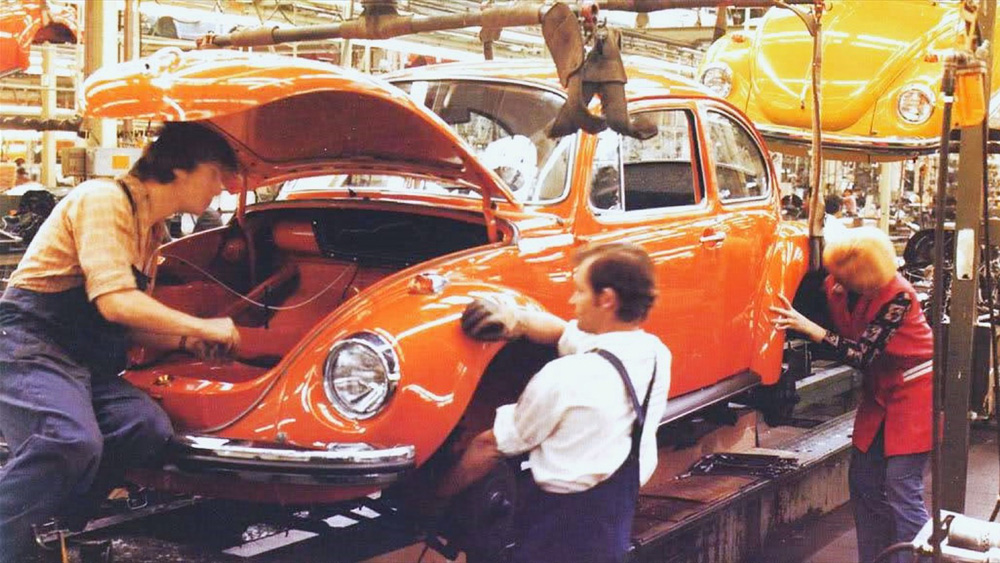 Bright colours in final assembly Hall 12 at the Volkswagen plant in Wolfsburg as another completed body on the 1303 line is lowered onto its respective chassis