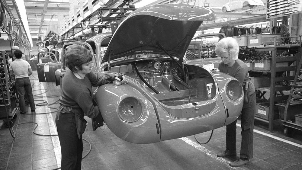 Two workers installing turn signals on a 1302 Super Beetle in Wolfsburg